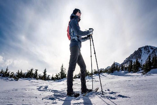 A guest in snowshoes, holding hiking poles