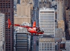 A bright red helicopter flying over the city of San Francisco on the Alcatraz and San Francisco Sites Helicopter Tour.