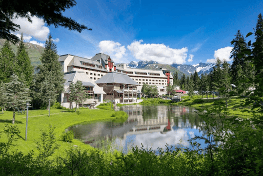 Refreshing resort exterior with mountain view and majestic lake.