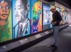 A young man looking at multicolored pieces of art at the Dark Testament: A Century of Black Writers on Justice at the American Writers Museum.