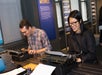 A man and woman sitting at black typewriters at the Story of the Day exhibit in the Mind of a Writer gallery at the American Writers Museum.