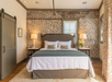 A guest room featuring a barn-style door, and a king bed