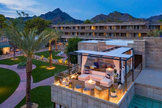 Outside lounge area with mountains in the background at dusk.