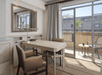 A large work desk and a private balcony with views of the surrounding inside a suite.