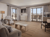Living space with a sofa, a large desk and a private balcony.