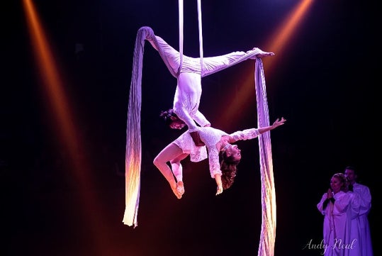 Amazing aerialists soar gracefully over the Array stage in a mid-air white ribbon performance.