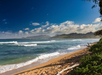 A sun-drenched beach with soft golden sands and turquoise waves.