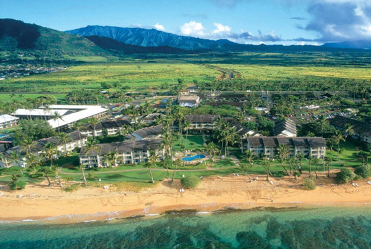 A tranquil hotel exterior nestled in lush greenery, offering a serene escape with breathtaking ocean views.