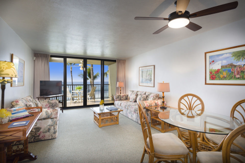Private living room with seating area, dining table & chair, and balcony with view.
