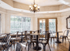 The breakfast dining area with dark brown chairs and tables in a room with lots of windows at the Baechtel Creek Inn.