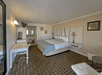 A hotel room with a king bed, a work desk and a flat-screen TV and a bathroom at the Baechtel Creek Inn.