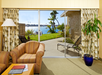 Guest room with sofa seating and patio with bay view.