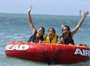 Young women having fun riding in an inflatable bumper tube.