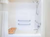 Accessible bath and shower combo with grab bars inside a private bathroom.
