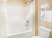 Fresh towels, a toilet, and a bathtub inside a private bathroom.