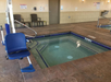 Indoor hot tub featuring a pool lift.