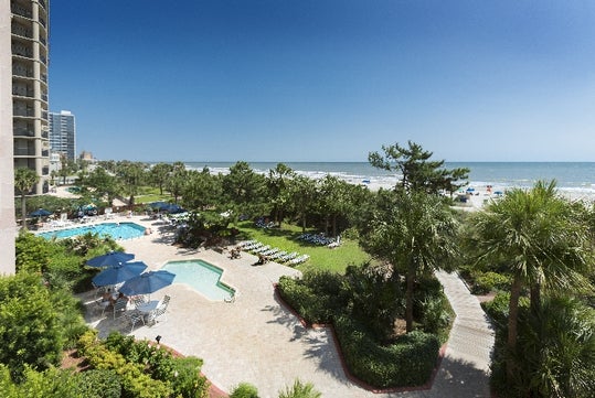 Oceanfront pool deck and view at Beach Colony Resort.