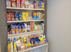 Shelves filled with various snack bags, boxes, and bottled drinks, including chips, cookies, candy, and soda.