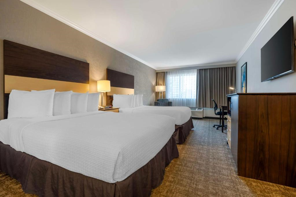Relax and work with two cozy queen beds, a functional desk, and a TV.