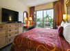 1 King bed, flat-screen TV and desk inside a guest room at Best Western Naples Inn & Suites, FL.