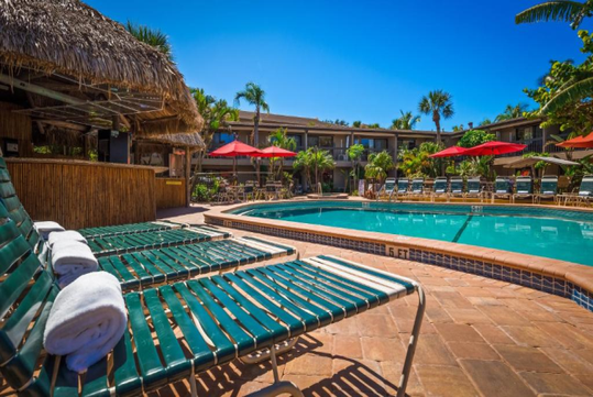 Outdoor pool with sun loungers at Best Western Naples Inn & Suites, FL.