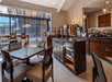 Breakfast area with different food selection such as cereals, fruits, waffles and omelet.