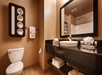 Guest bathroom with mirror, toilet, sink, and towels.