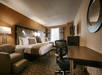 One king bed and a work area inside a guest room.