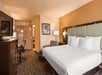 One king bed, flat-screen TV, desk, and seating area in a guest room.