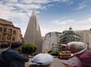 A group of people in the foreground look toward the Transamerica Pyramid skyscraper in downtown San Francisco on a partly cloudy day.