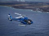 A helicopter flying along the coast while some active lava flow cools as it meets the ocean on the Big Island Spectacular Helicopter Tour in Hawaii USA.