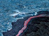 Above the most geologically active region on earth, a Blue Hawaiian Eco-Star glides close to a lava river.