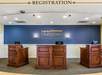 Registration desk with three wooden counters and a blue wall labeled "Bluegreen Parkside Williamsburg.