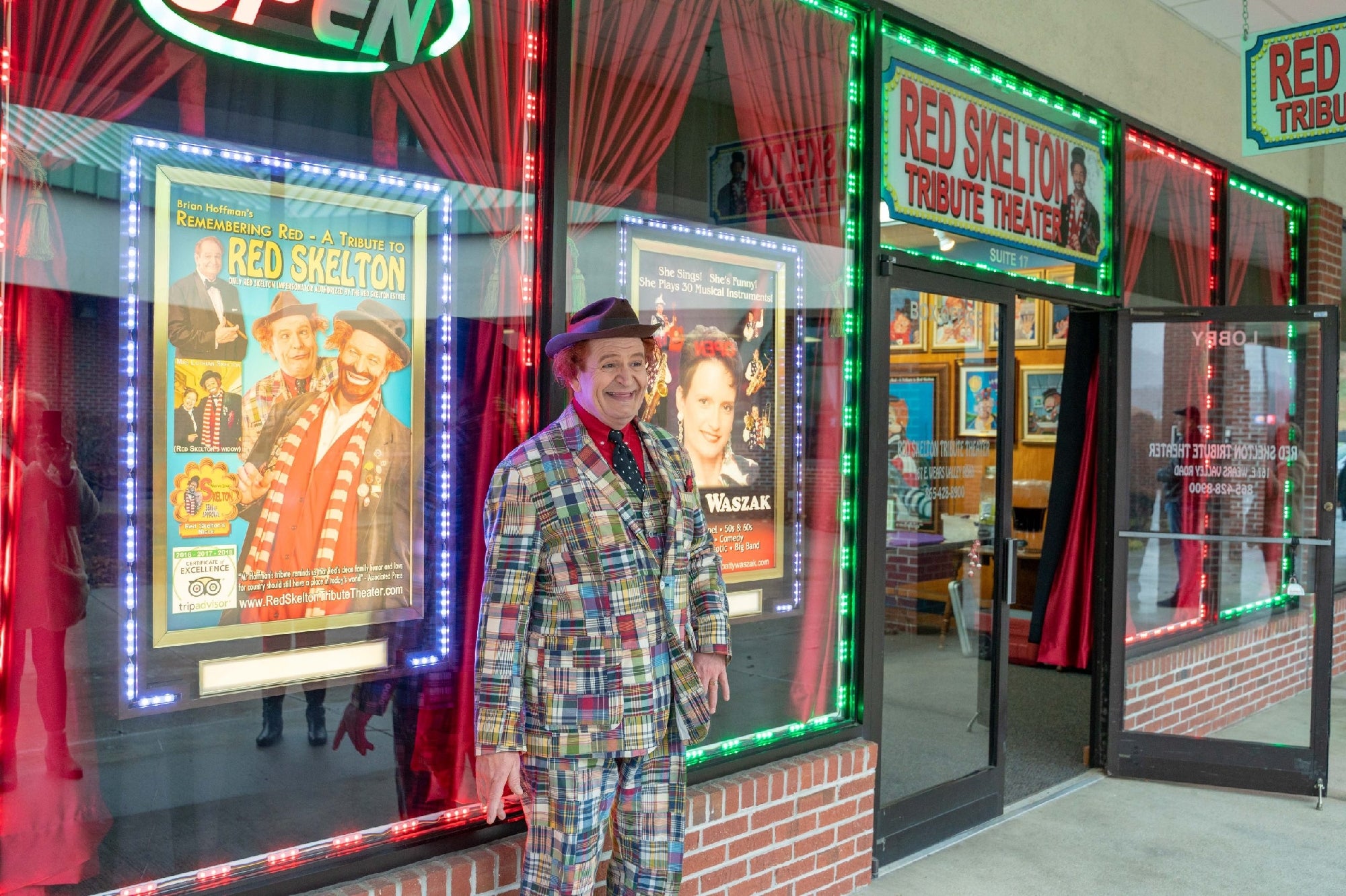 Greeting guests outside the glowing neon entrance of the Red Skelton Tribute Theater.