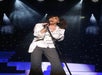 A man singing on stage in the British Invasion Show at the Americana Theatre in Branson Missouri.