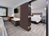 A king bed in a separate bedroom, a workspace, and a wall-mounted TV inside a guest room