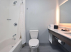 Private bathroom with vanity area, toilet, and a bathtub