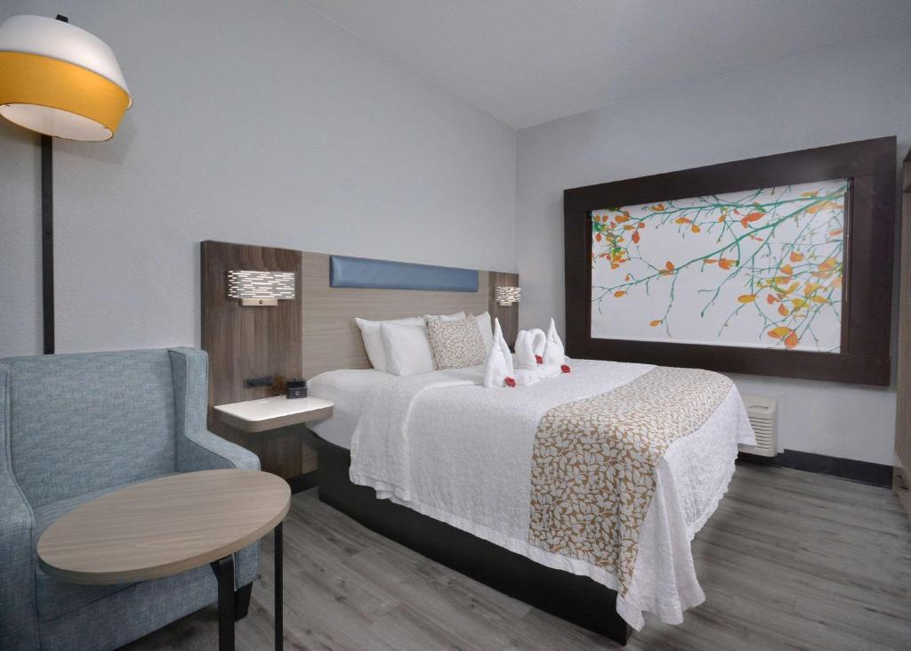 A King bed and a comfortable soft seating inside a guest room