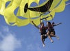 A couple soaring through the sky, enjoying a thrilling parasailing adventure