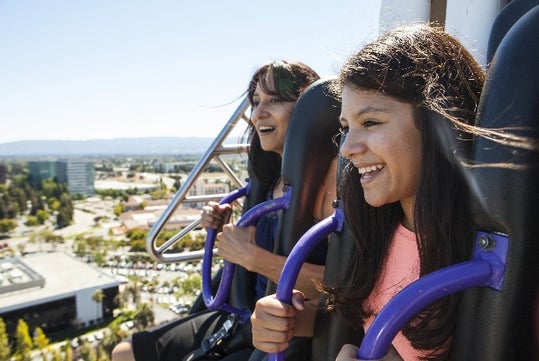 Two young women smiling in the air while riding the Drop Tower at California's Great America in San Francisco, California.