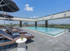 Rooftop outdoor pool with sun loungers and umbrellas.