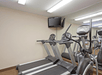 Fitness room with two treadmills, and other cardio equipment, and a flat-screen TV.