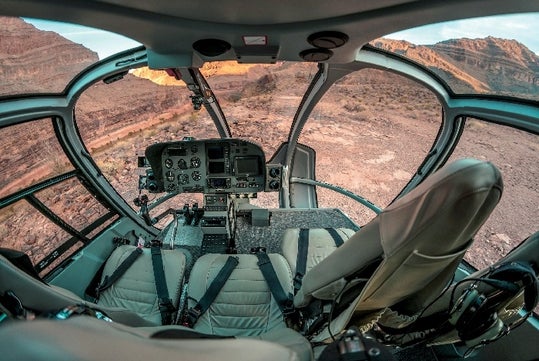 The cockpit of a Maverick Airbus helicopter with the majestic view of the Grand Canyon below them.