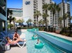 Guests lounging by the lazy river and children on the tubes enjoying the lazy river.