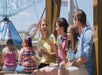 A family sitting down and eating ice cream and drinking water at Carowinds in Charlotte, North Carolina.