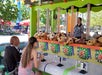 Two teenagers sitting and playing a carnival game where you shoot water at a target to win a price.