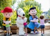 Charlie Brown, Snoopy, and Lucy mascots hugging children at Cedar Point.