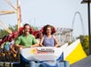 A man and woman sitting at the front of the Top Thrill Dragster rollercoaster getting their hair blown back.