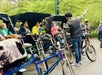 A pedicab guide points out landmarks to guests in Central Park.