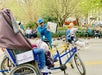 Central Park pedicab guide shows guests a photo album of movie locations during a stop near Bethesda Terrace.